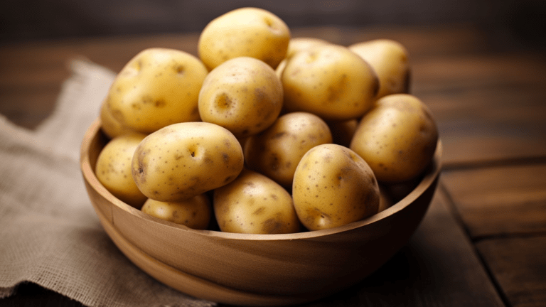 En samling färska potatisar på ett träbord.